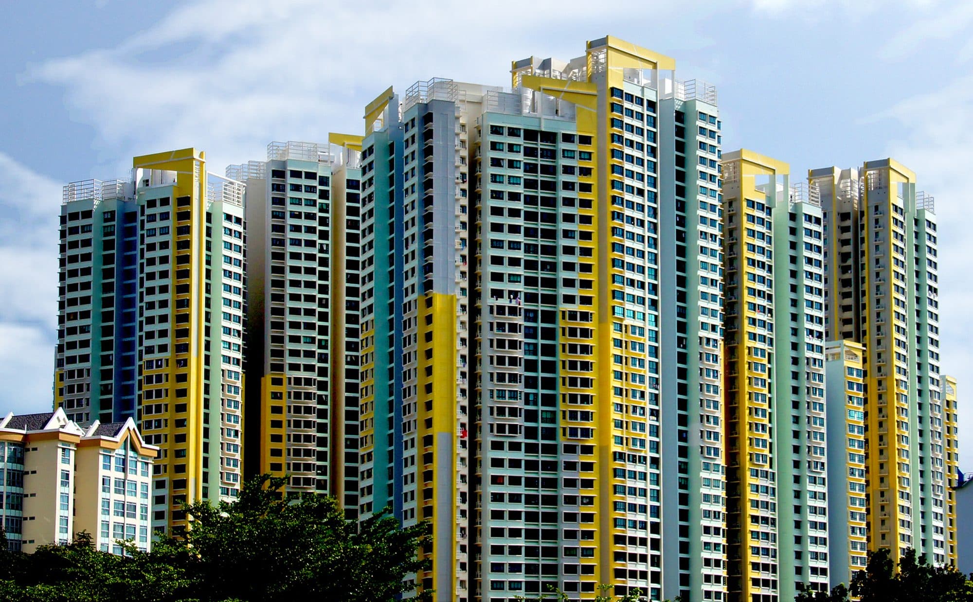Blok flat HDB bertingkat tinggi di Singapura, bercat kuning pucat, hijau dan putih